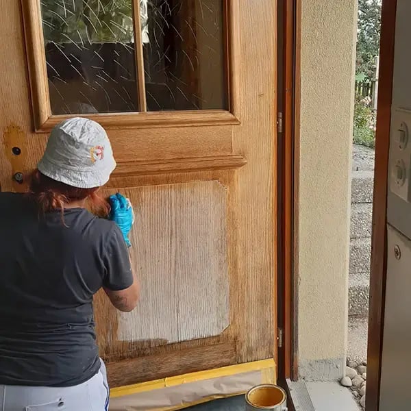 Vanessa Bertschy am lasieren der Holztüre