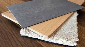 drei verschiedene Bodenbelagsarten: Linoleum, Laminat und Teppich