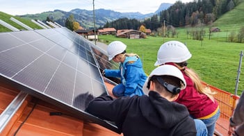3 Kinder auf dem Dach, montieren Solar-Panels, Ausblick auf die Berge