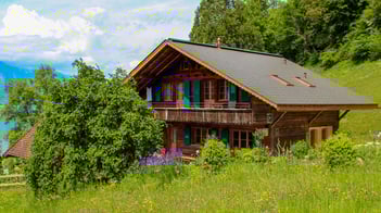 Gästehaus Merligen nach energetischer Sanierung von sattem Grün umgeben