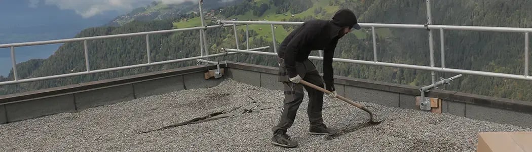 Mit_Schaufel_Kiesabdeckung_wegschaufeln