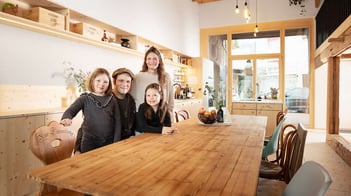 Familie Rapold versammelt sich am Tisch; im Hintergrund ist frisch sanierte Küche und Fenster sowie Türe zu sehen