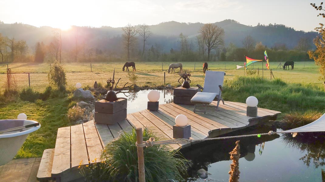 Naturteich im eigenen Zuhause, persönliche Oase mit Sonnenuntergang und Ausblick auf Weide mit Pferden